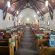 A picture of the sanctuary with many blankets laid over the pews to show our set up for our sewing group blanket sale to support CLWR